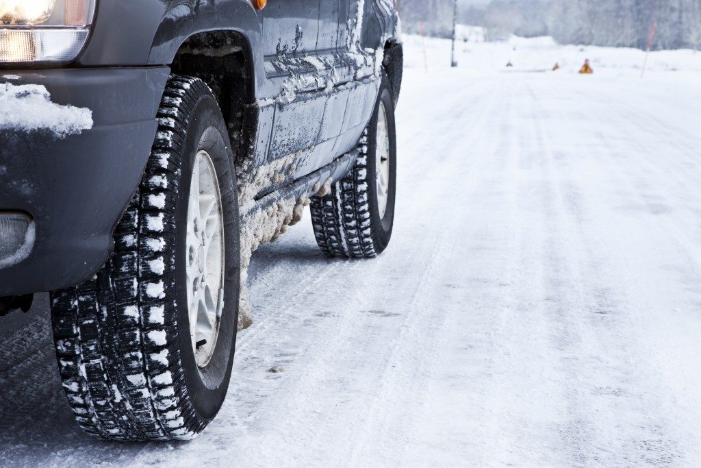 Close up of a cars tires on a snowy road