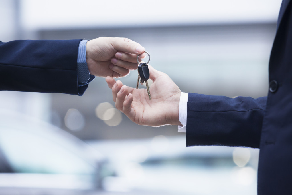 Car salesman handing over the keys for a new car