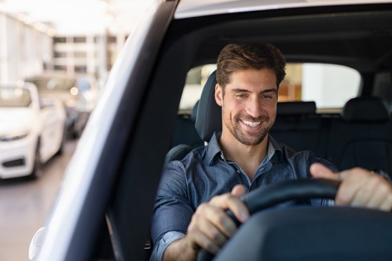 man smiling while driving